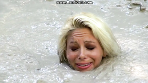 Bizarre Fetish Scene Featuring Busty Blonde Sinks In Lake Of Dirt