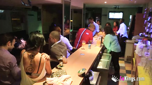 A party girl with tattooes gives blowjob to 2 guys in public